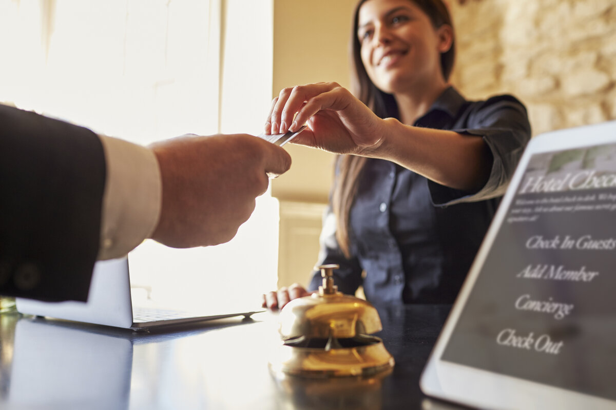 a hotel receptionist handing a credit card to someone