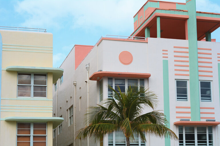 A colorful building with a palm tree in front of it.